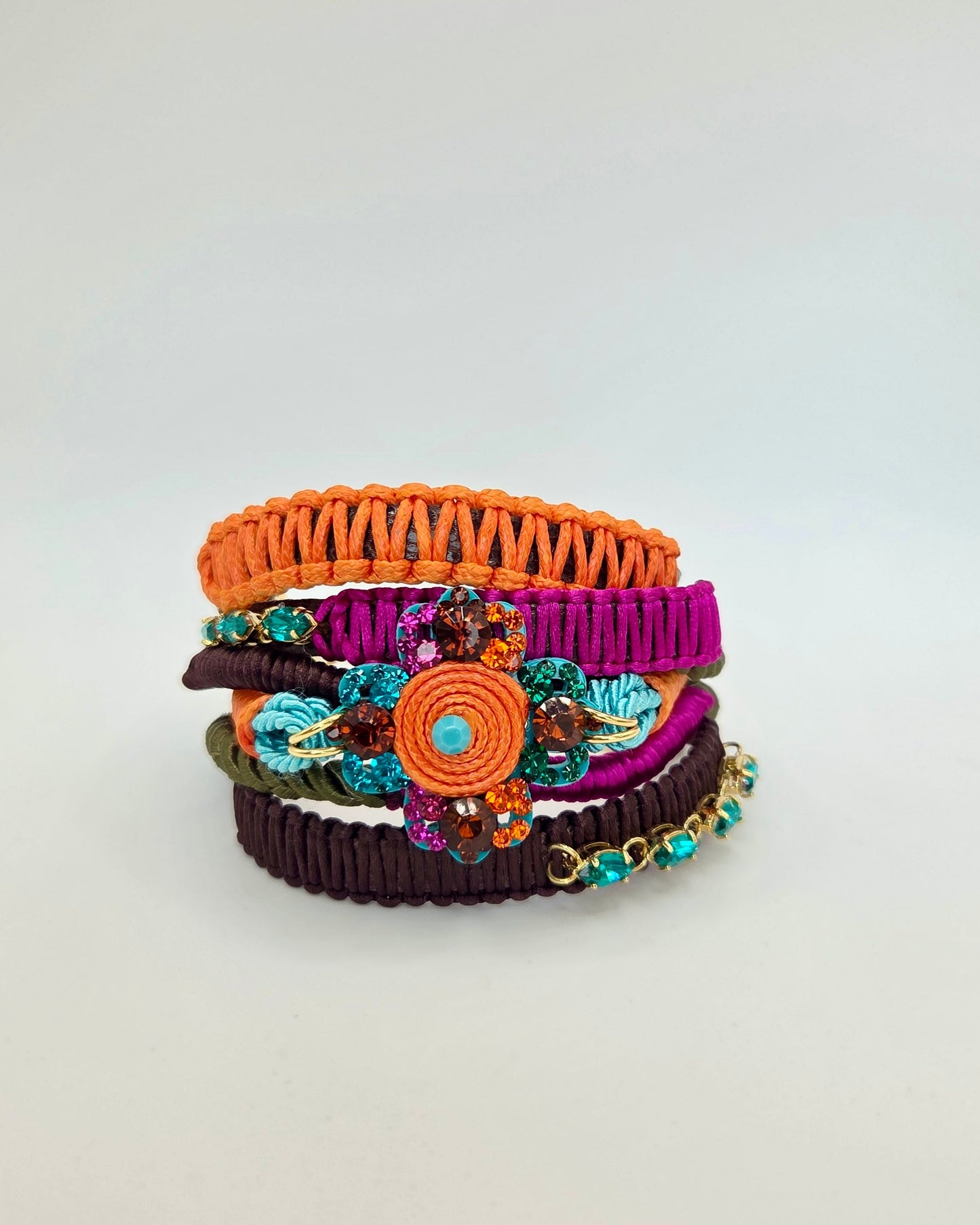 Stack of colorful macramé bracelets on a light gray background