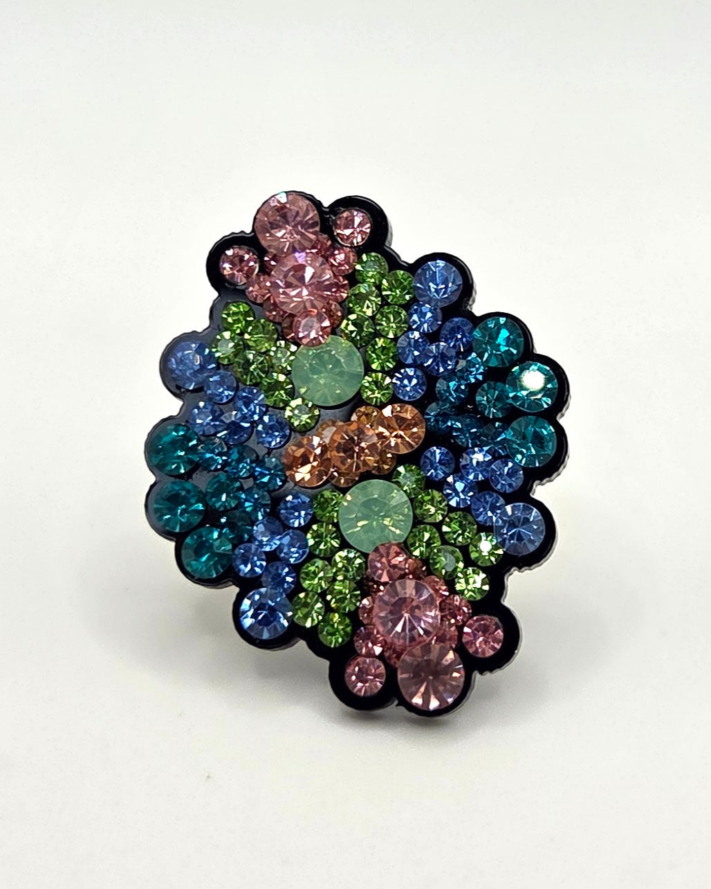 Multicolored gemstone brooch on a white background