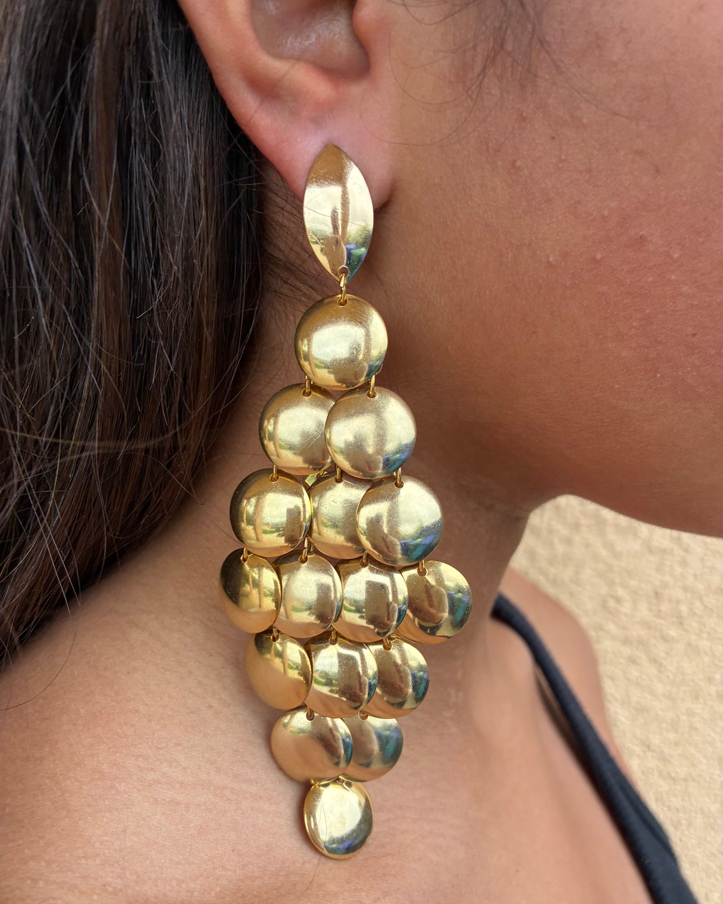 Gold chandelier earring worn by a person