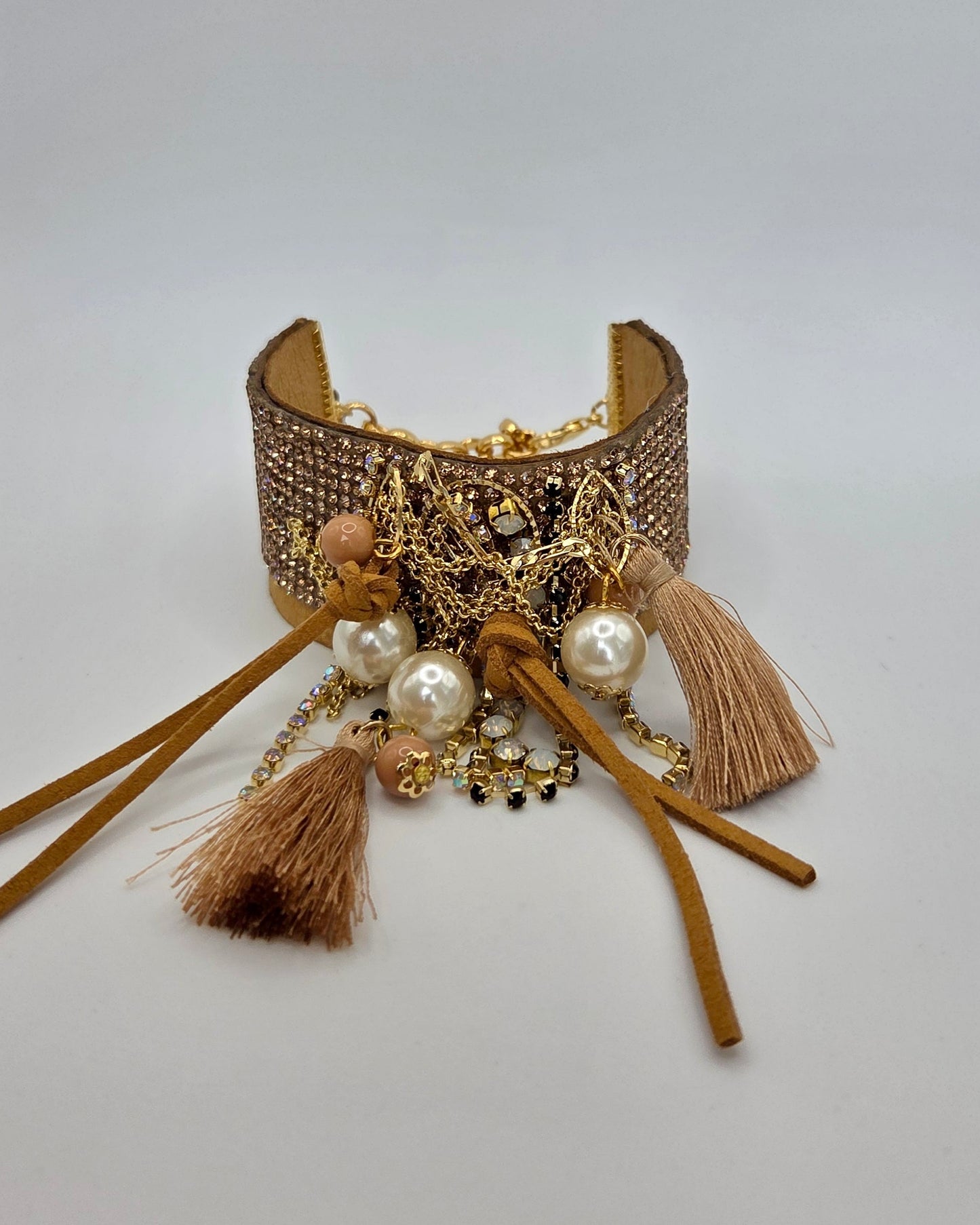Decorative bracelet with tassels and beads on a light gray background