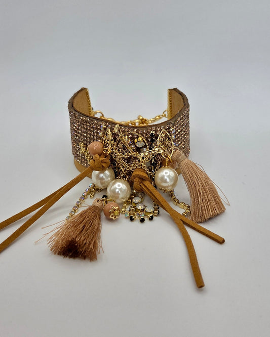 Decorative bracelet with tassels and beads on a light gray background