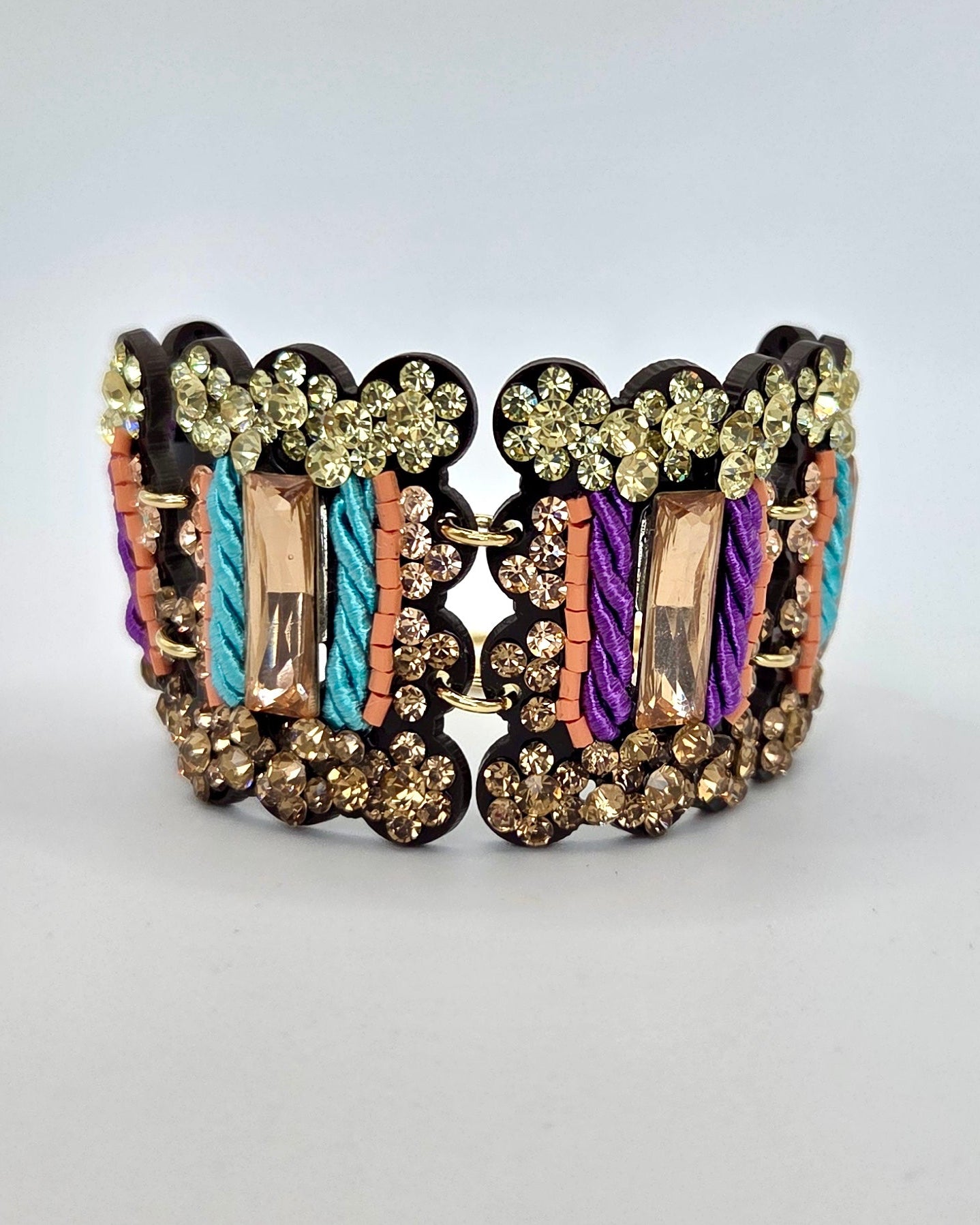 Decorative bracelet with multicolored stones on a light gray background