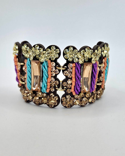 Decorative bracelet with multicolored stones on a light gray background