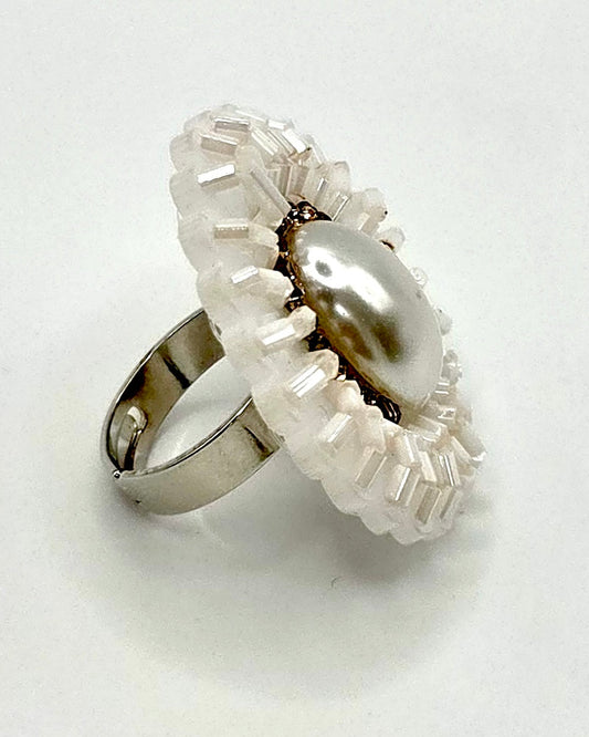 Silver ring with a pearl and decorative elements on a white background