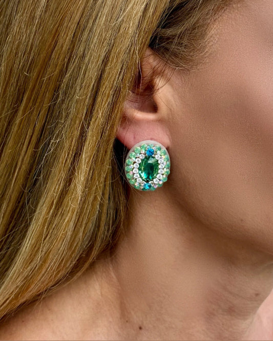 Close-up of a person wearing a green gemstone earring.