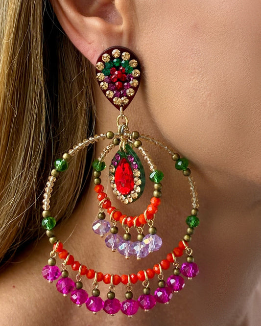 Colorful beaded earrings worn by a person