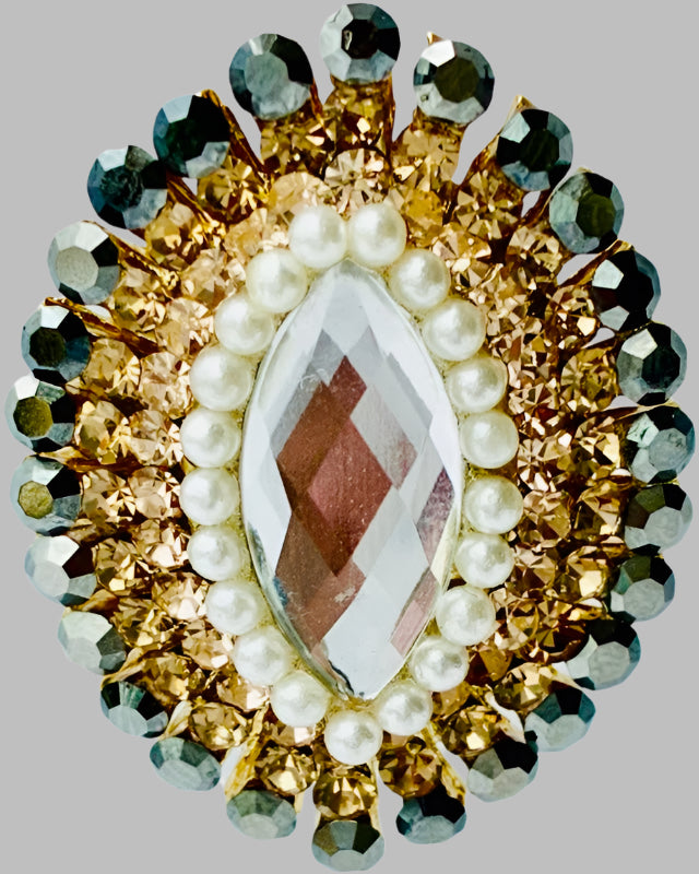 Jewelry piece with central gemstone surrounded by pearls and gemstones on a gray background
