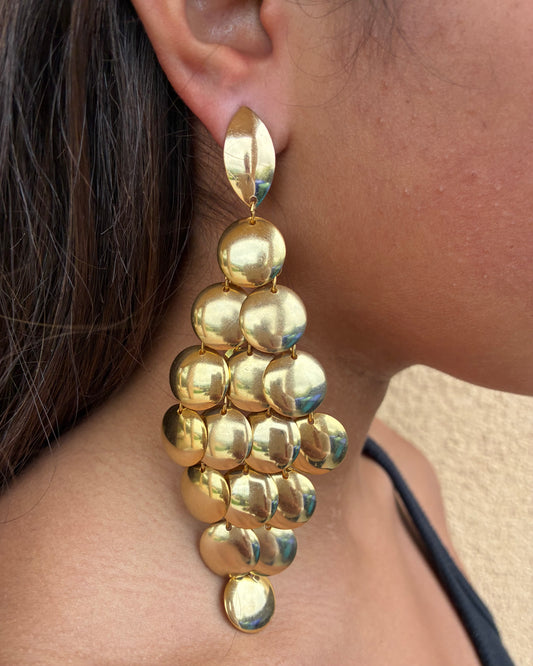 Gold chandelier earring worn by a person
