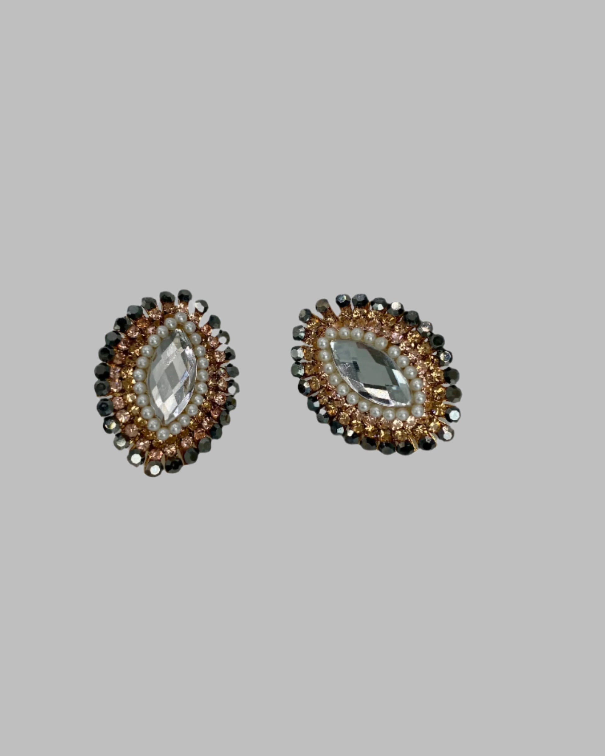 Pair of earrings with marquise-shaped gemstones on a gray background