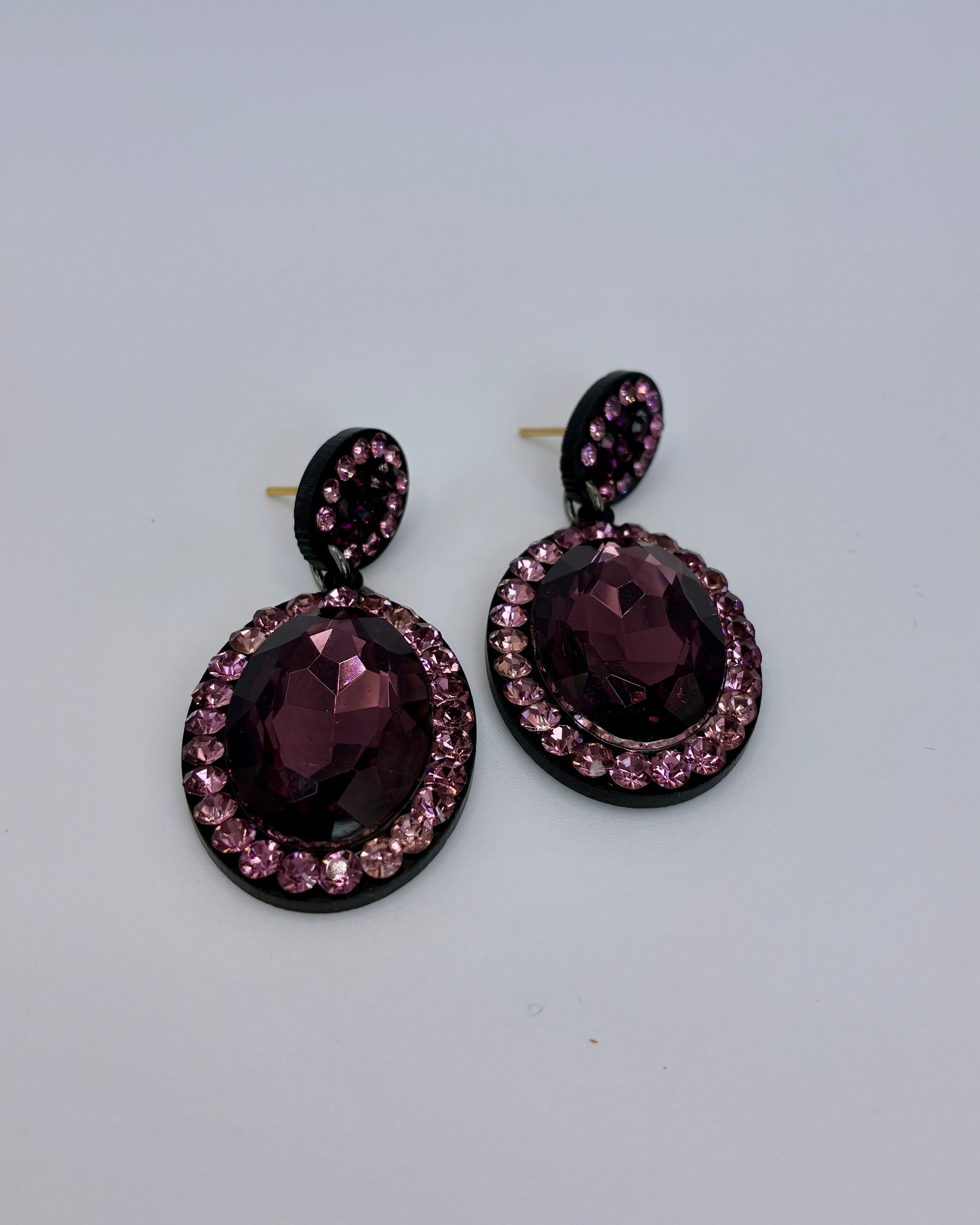 Pair of purple gemstone earrings on a light gray background