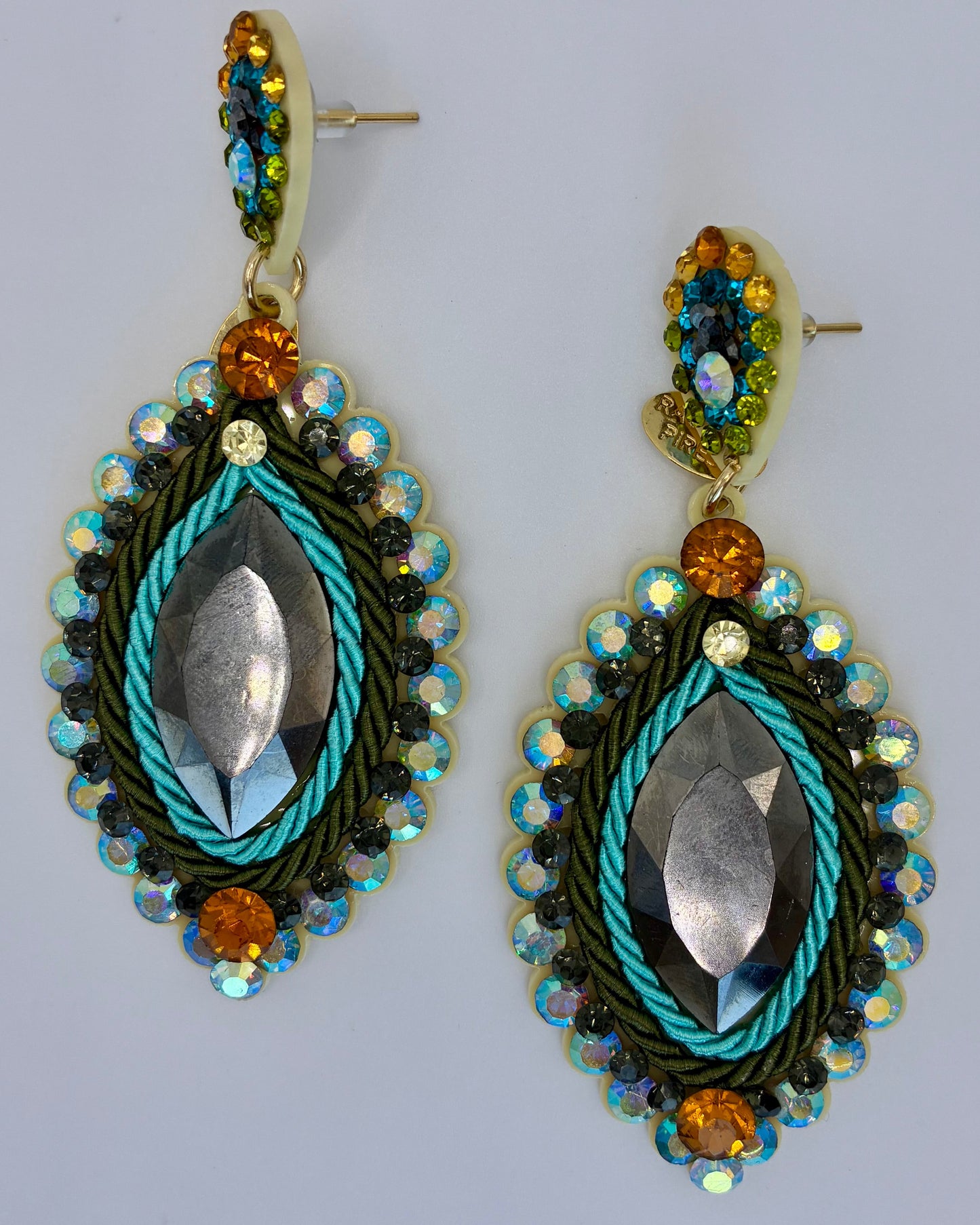 Decorative earrings with beads and metallic elements on a light gray background