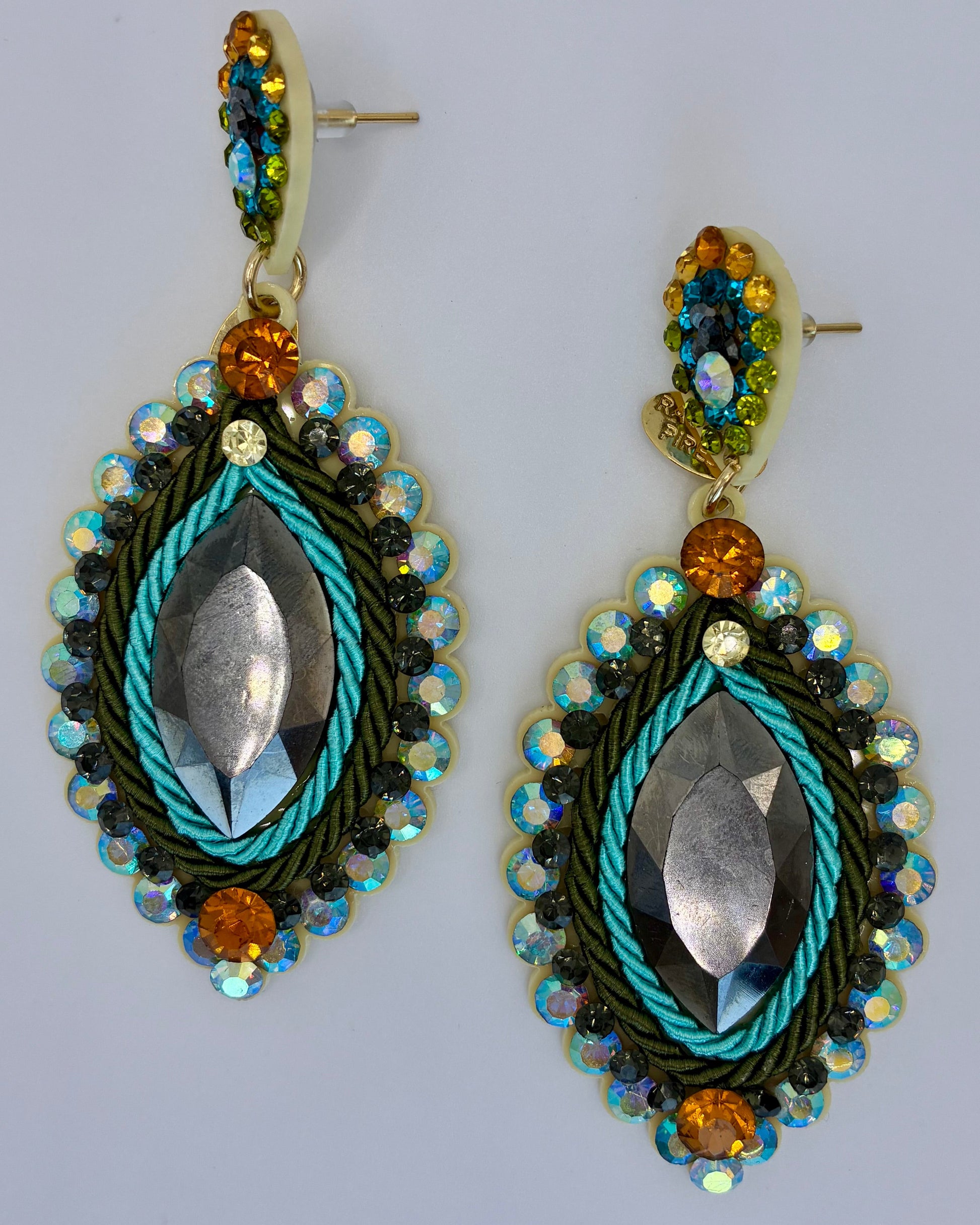 Decorative earrings with beads and metallic elements on a light gray background