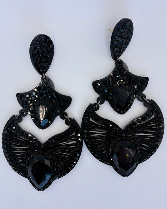 Pair of black butterfly-shaped earrings on a white background