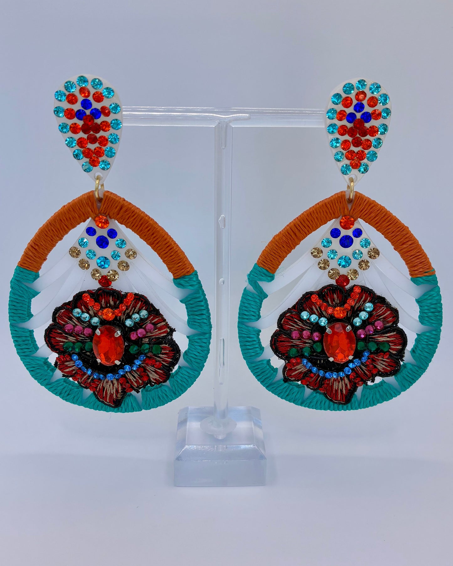 Colorful earrings with intricate designs on a white background