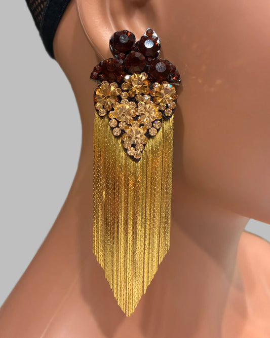 Gold tassel earring with gemstones on a mannequin ear